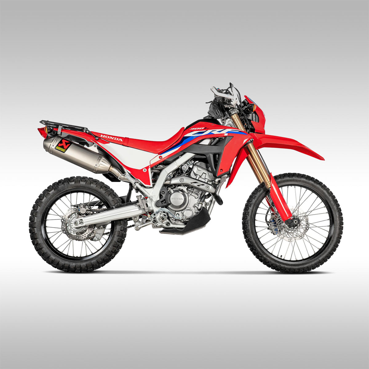 Side view of a Honda CRF300L. Akrapovice slip-on exhaust for the Honda CRF300L and CRF300L Rally. Off-Road  specific design from the engineeres at Akrapovic. Stainless steel and titanium construction.