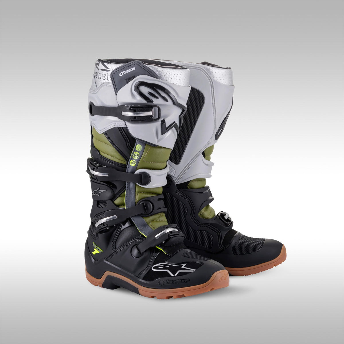 Alpinestars Tech 7 Enduro boots in the Black, Silver and Army Green. The left and right boot next to each other. Enduro and dualsport motorcycle boots. Protective gear for dirtbike riding.